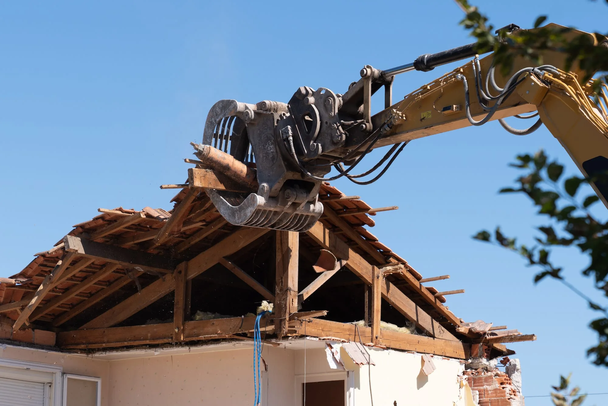 Excavator demolishing a residential structure
