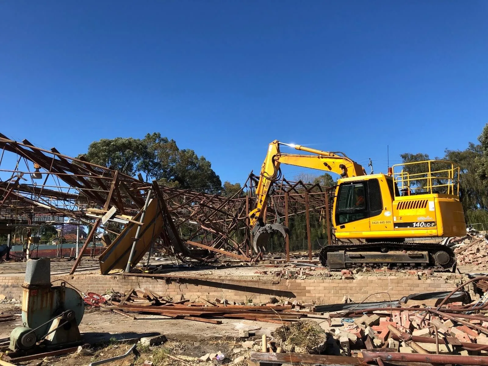 Site mid-demolition with debris being cleared